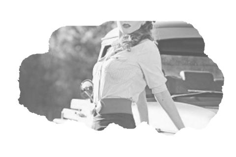 Statuesque redhead reclines on classic automobile